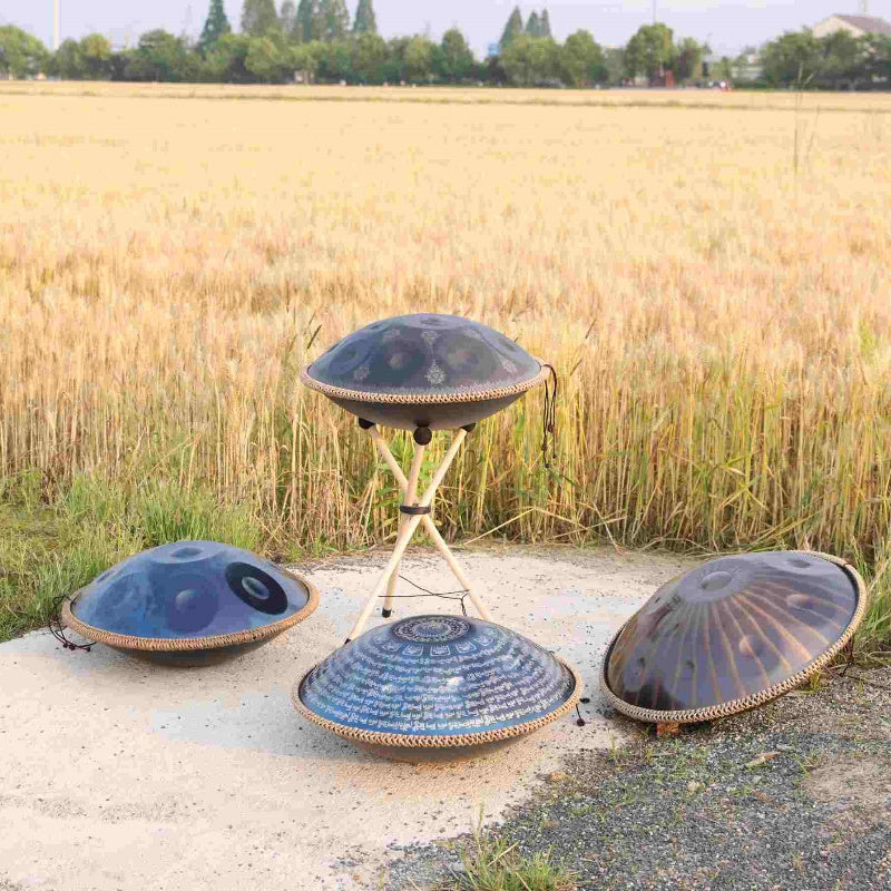 Various handpan drums showcased amidst a picturesque wheat field.