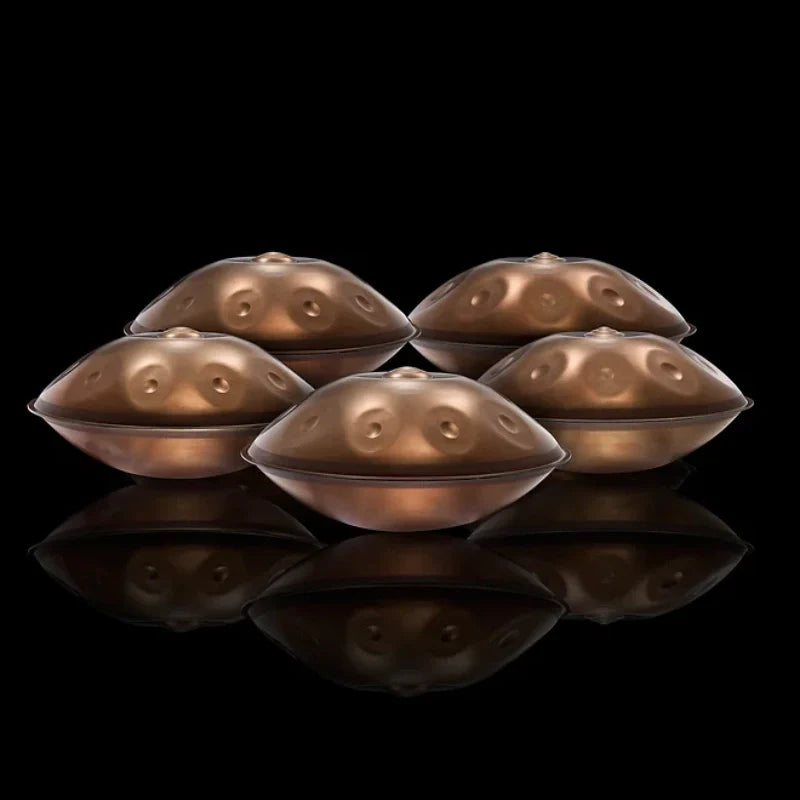 Close-up of four identical golden handpans showing detailed craftsmanship and design.