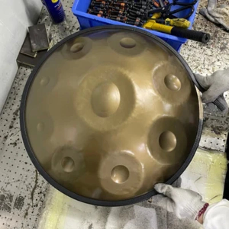 Craftsmen tuning a hang drum in a workshop