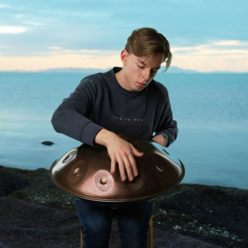 Musicians playing handpan on the beach at sunset