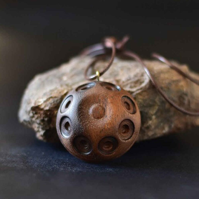 Handpan-inspired pendants crafted with unique designs, capturing the melodic beauty and artistic vibe of the handpan in wearable jewelry.