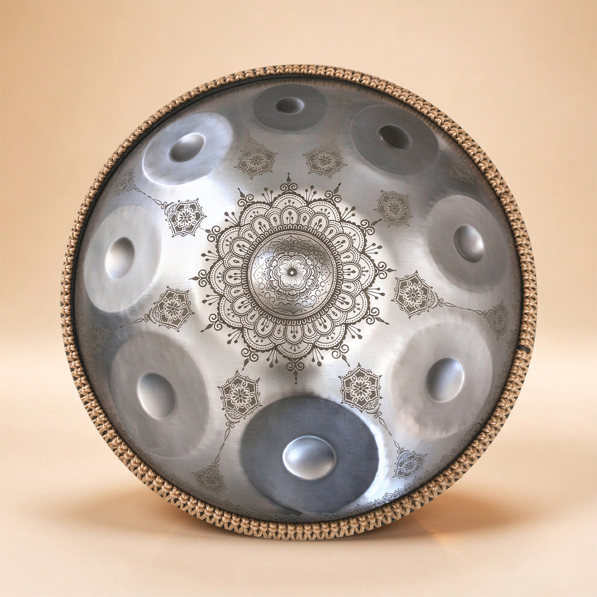Silver handpan with delicate floral etchings and shimmering tones