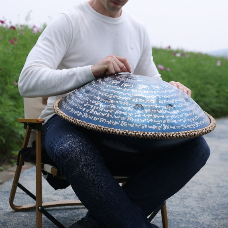 Male artists concentrate on playing handpan on their own stools in the garden.